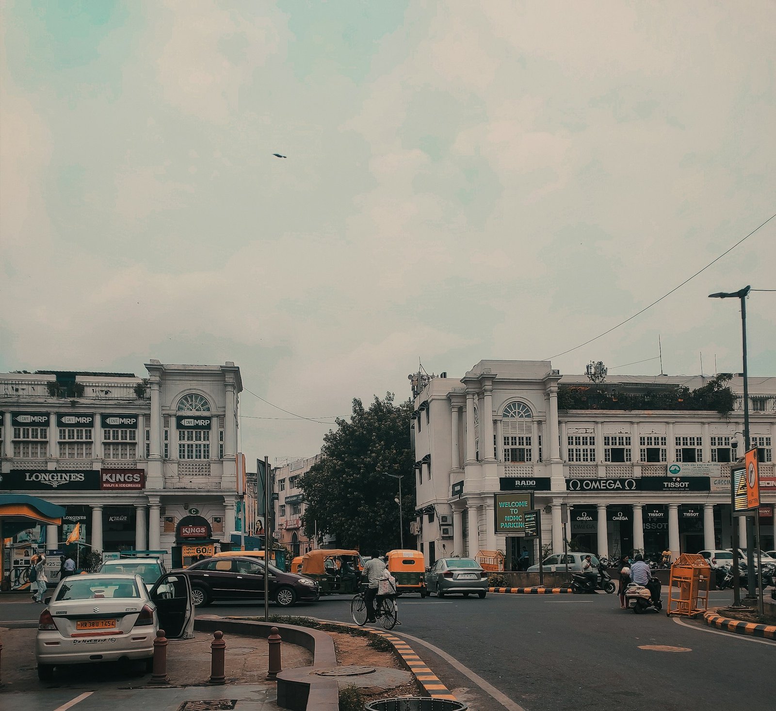 White colonnaded buildings and traffic on a street in New Delhi
