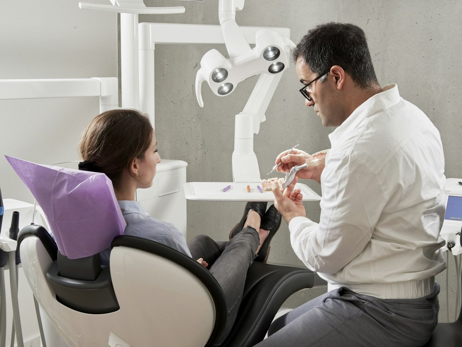 A dentist talking with a patient in the treatment chair