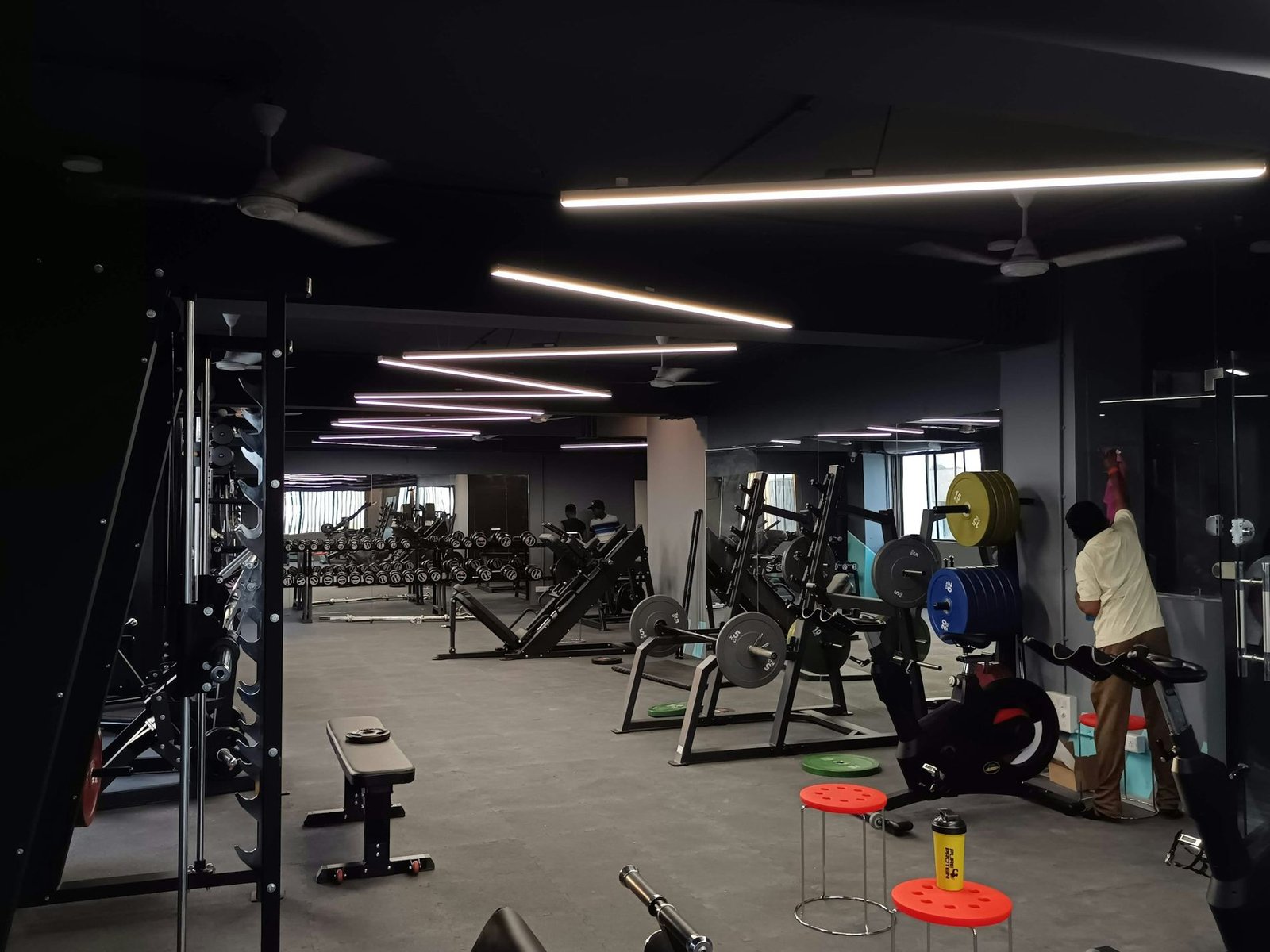 The weights floor of a gym with members training