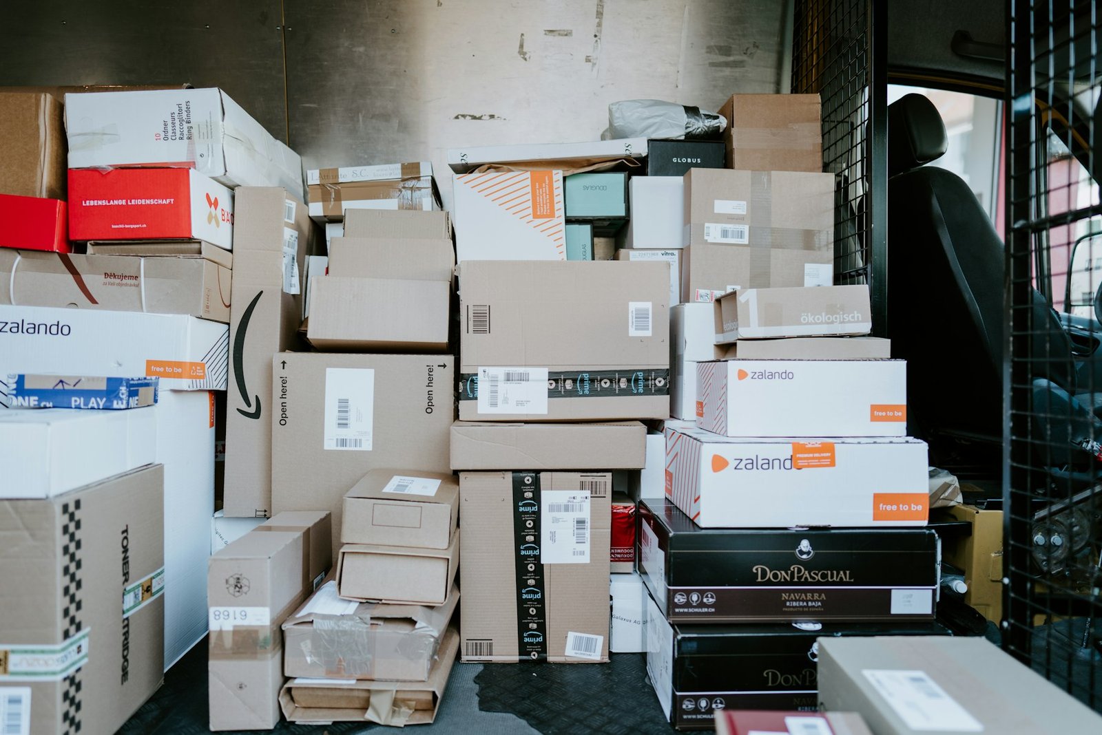 Cardboard shipping boxes stacked inside a delivery van